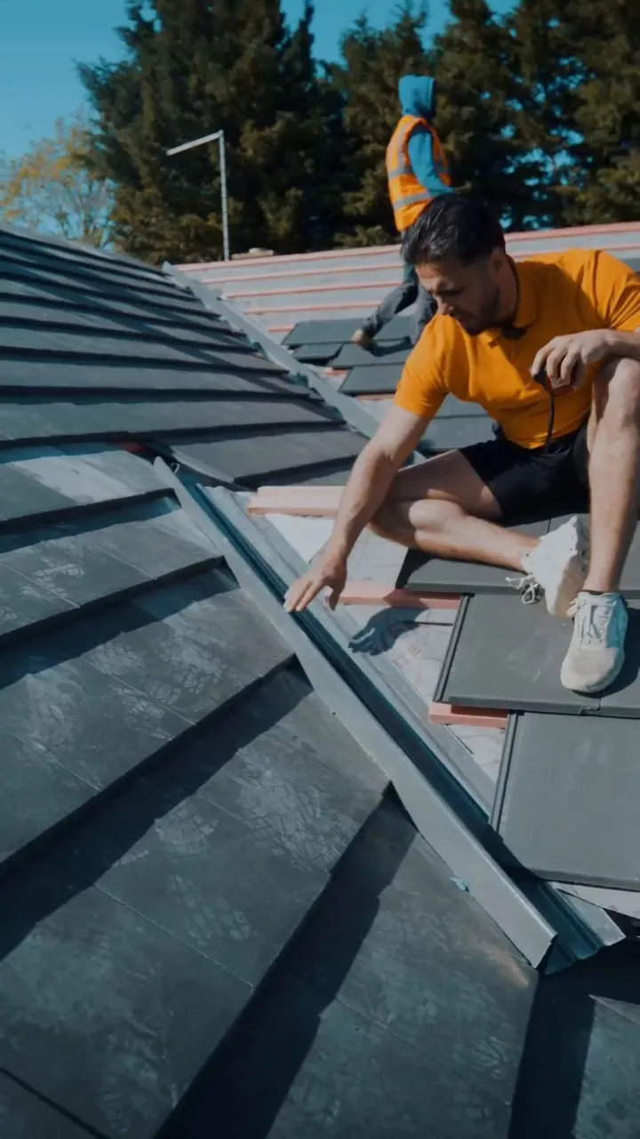 One of our roofers fixing new tiles on a Peterborough roof